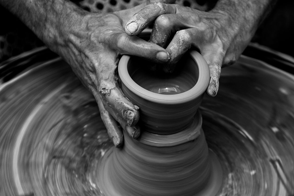 Hands making a clay pot