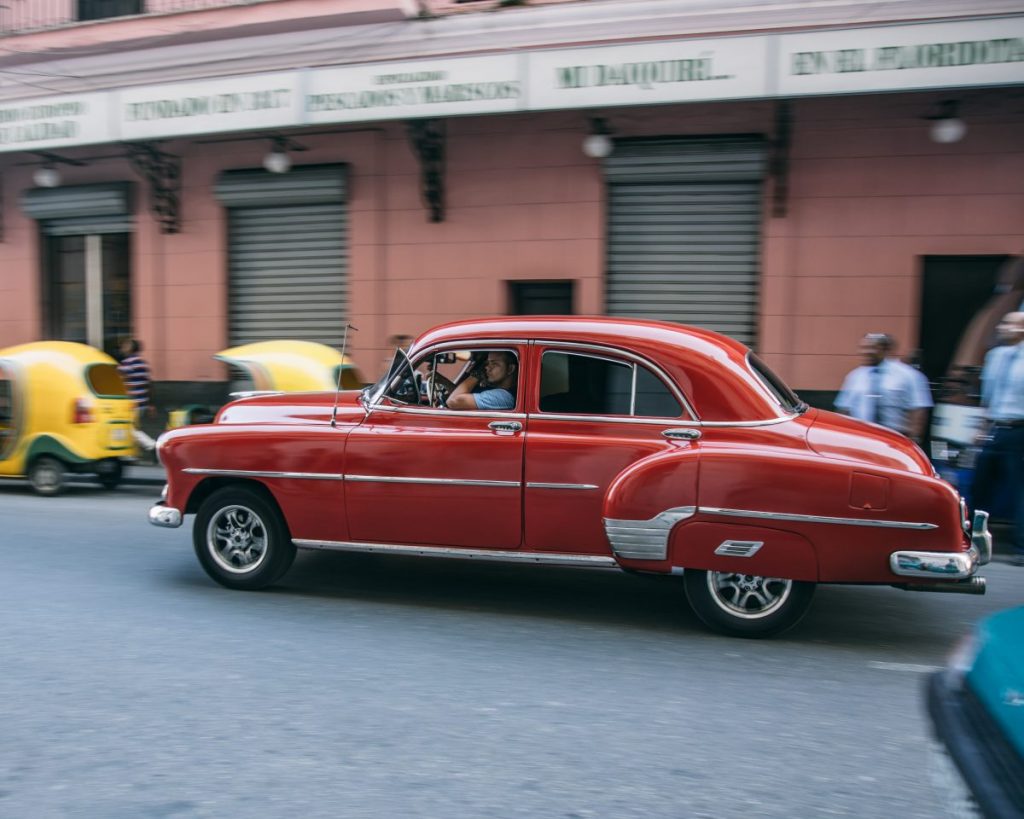 Vintage red car driving in Havana